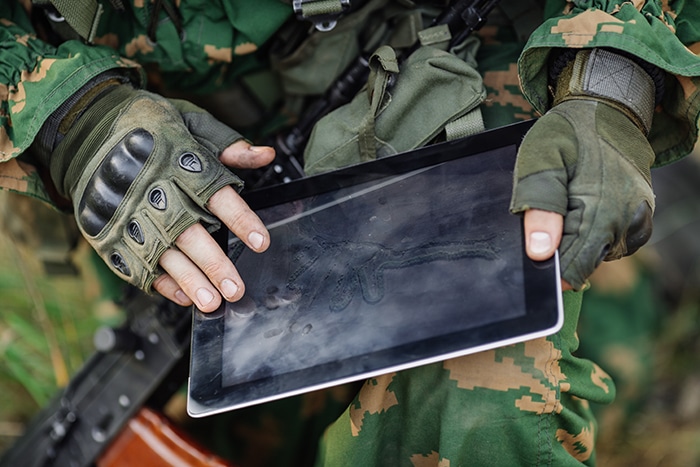 Photo d'un militaire lisant une carte sur une tablette